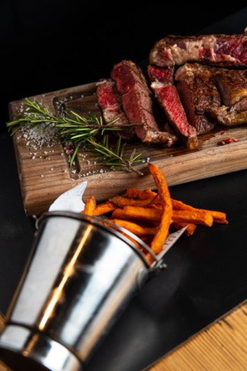 Sliced steak with sweet potato fries at MEAT30